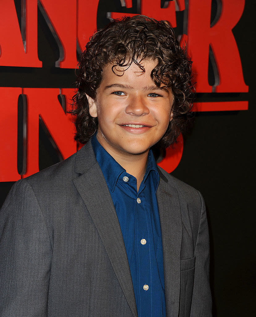 young Gaten with long curly hair