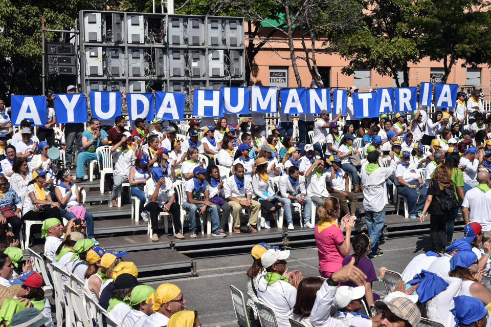 Voluntarios del movimiento 'Coalición para la Ayuda y la Libertad en Venezuela' sostienen hacen una pancarta con letras durante una protesta liderada por Juan Guaidó en Caracas, el 16 de febrero de 2019