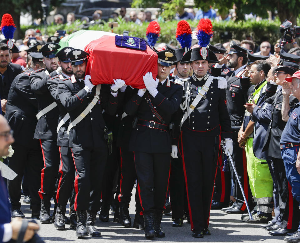 The coffin containing the body of Carabinieri's officer Mario Cerciello Rega is carried to his funeral in his hometown of Somma Vesuviana, near Naples, southern Italy, Monday, July 29, 2019. Two American teenagers were jailed in Rome on Saturday as authorities investigate their alleged roles in the fatal stabbing of the Italian police officer on a street near their hotel. (AP Photo/Andrew Medichini)