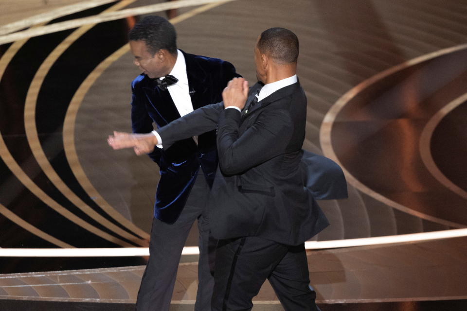 Will Smith (R) punches Chris Rock as Rock spoke onstage during the 94th Academy Awards in Hollywood, Los Angeles, California, U.S., 27 March 2022. Picture taken 27 March 2022. REUTERS/Brian Snyder BEST QUALITY AVAILABLE