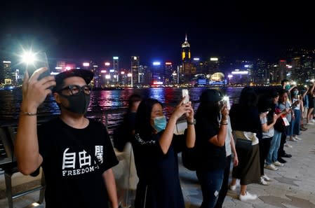 Protesters hold hands to form a human chain during a rally to call for political reforms at the Avenue of Stars in Hong Kong