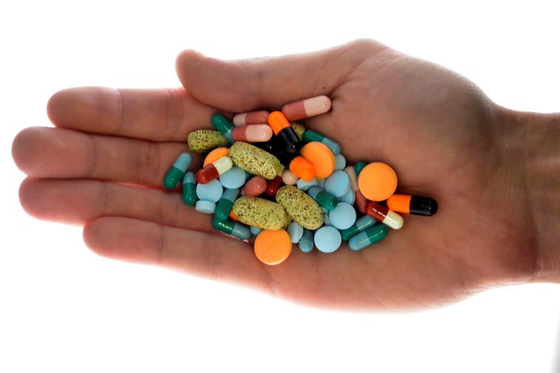 FILE PHOTO: A person holds pharmaceutical tablets and capsules in illustration picture in Ljubljana