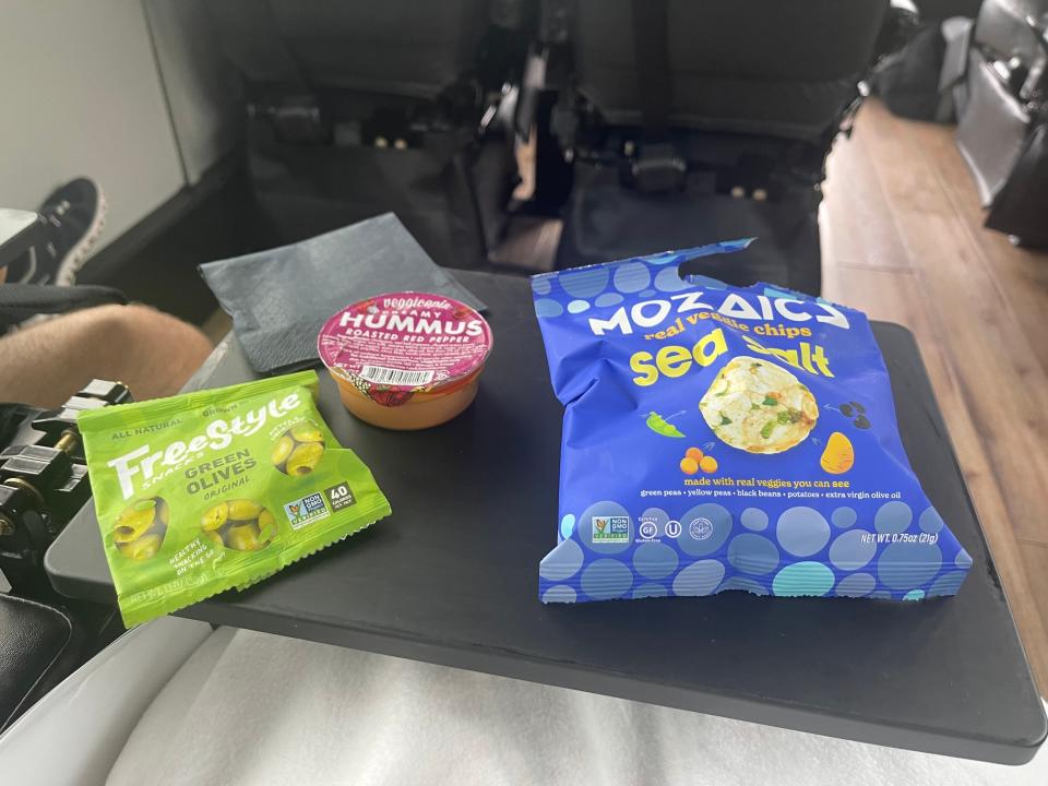 A view from the author's seat, where several snacks have been placed on her tray table.