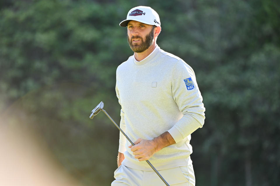 Dustin Johnson (pictured) walks with his putter on the 13th green.