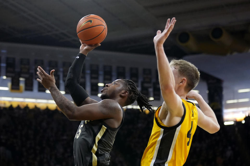 Purdue guard Lance Jones (55) shoots in front of Iowa guard Josh Dix, right, during the first half of an NCAA college basketball game, Saturday, Jan. 20, 2024, in Iowa City, Iowa. (AP Photo/Charlie Neibergall)