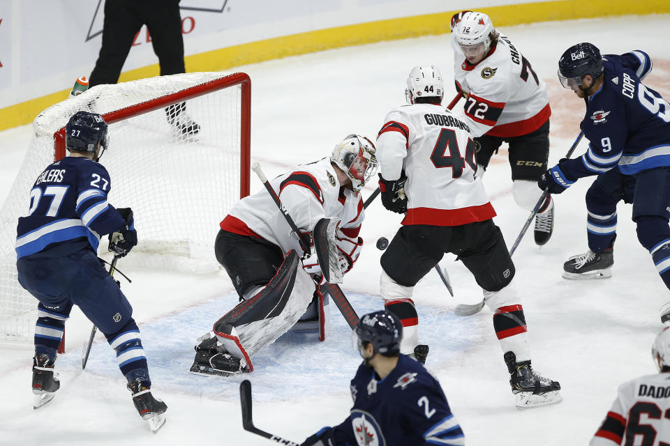 Winnipeg Jets' Andrew Copp (9) scores on Ottawa Senators goaltender Marcus Hogberg (1) during the third period of an NHL hockey game Saturday, Jan. 23, 2021, in Winnipeg, Manitoba. (John Woods/The Canadian Press via AP)