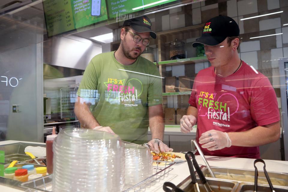 Tic Tac Taco employees Mark Nichols (left) and Jake Merchant prepare a customer's order Aug. 2 at the newly opened Duchess convenience store in New Albany.