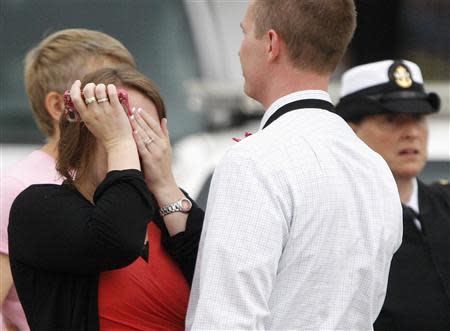 A woman wipes her tears as she is reunited with her husband, who was one of hundreds of Navy Yard workers evacuated to a makeshift Red Cross shelter after a shooting, at the Nationals Park baseball stadium near the affected naval installation in Washington, September 16, 2013. REUTERS/Jonathan Ernst