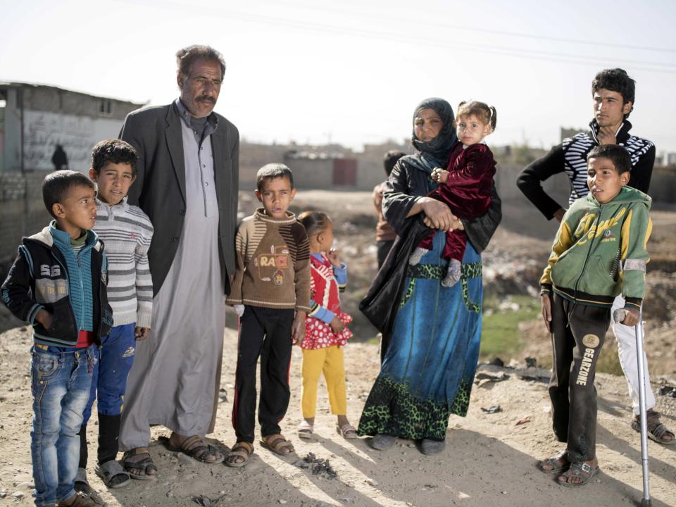 Khodr Ahmed and his wife Khodriya Ahmed stand with their children after escaping fighting in Mosul in this Nov. 12, 2016 photo taken in Gogjali, Iraq. With no job under Islamic State group rule, Khodr Ahmed sold his car to buy food and then when that money ran out, he had to send his sons out to scrounge for scrap metal to sell. His son Bashir, 9, (fourth from left) picked up unexploded ordnance that blew off his hand and wounded the leg of his brother Mushal, 10 (with crutch). IS militants were “living the good life. They had food to eat,” Khodr Ahmed said. “But because we did not join there was nothing for us.” (AP Photo/Nish Nalbandian)
