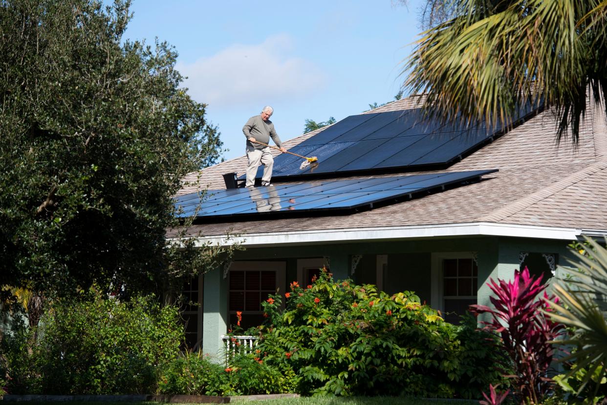 Jerry Buechler, of Port St. Lucie, cleans the 28 solar panels on his roof Wednesday, Dec. 4, 2019, in Port St. Lucie. Buechler has converted his 4-bedroom, 3-bathroom house to completely run off solar energy and also drives an electric vehicle and uses an electric lawn mower. He formed the Treasure Coast Solar Co-op with fellow retired Miami Beach firefighter Richard Silvestri after seeing streets in Miami Beach flooding on sunny days and watching the city spend over $500 million raising streets and putting in pumps. "It's a short-term solution to a long-term problem. The only real solution... is to reduce our carbon footprint," Buechler said.