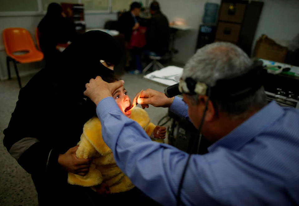 <p>Palestinian girl Nour Seyam, 3, who suffers from tonsillitis, is checked by a doctor at an outpatient clinic at Shifa hospital, Gaza’s largest public medical facility, in Gaza City, March 29, 2017. (Photo: Mohammed Salem/Reuters) </p>