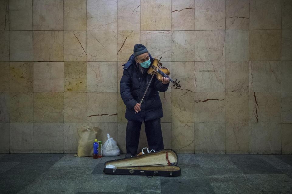 A busker plays the violin in the subway at Nyugati Square during the coronavirus emergency in Budapest, Hungary, March 18, 2020. (Zoltan Balogh/MTI via AP)