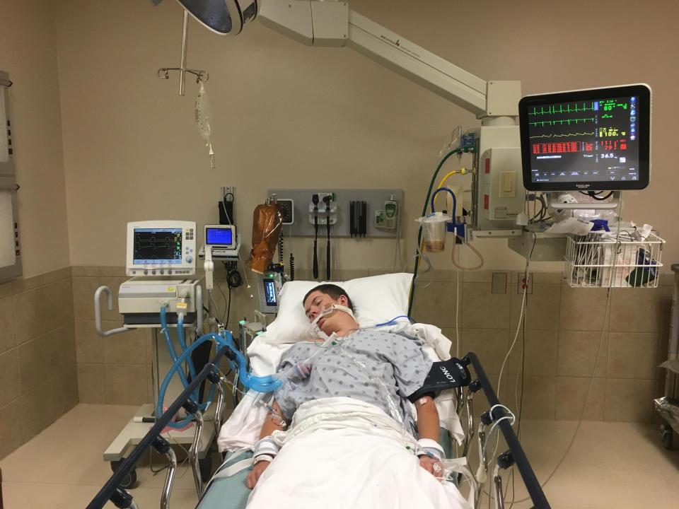 This May 2018, photo provided by Joseph Jenkins shows his son, Jay, in the emergency room of the Lexington Medical Center in Lexington, S.C. Jay Jenkins suffered acute respiratory failure and drifted into a coma, according to his medical records, after he says he vaped a product labeled as a smokable form of the cannabis extract CBD. Lab testing commissioned as part of an Associated Press investigation into CBD vapes showed the cartridge that Jenkins says he puffed contained a synthetic marijuana compound blamed for at least 11 deaths in Europe. (Joseph Jenkins via AP)