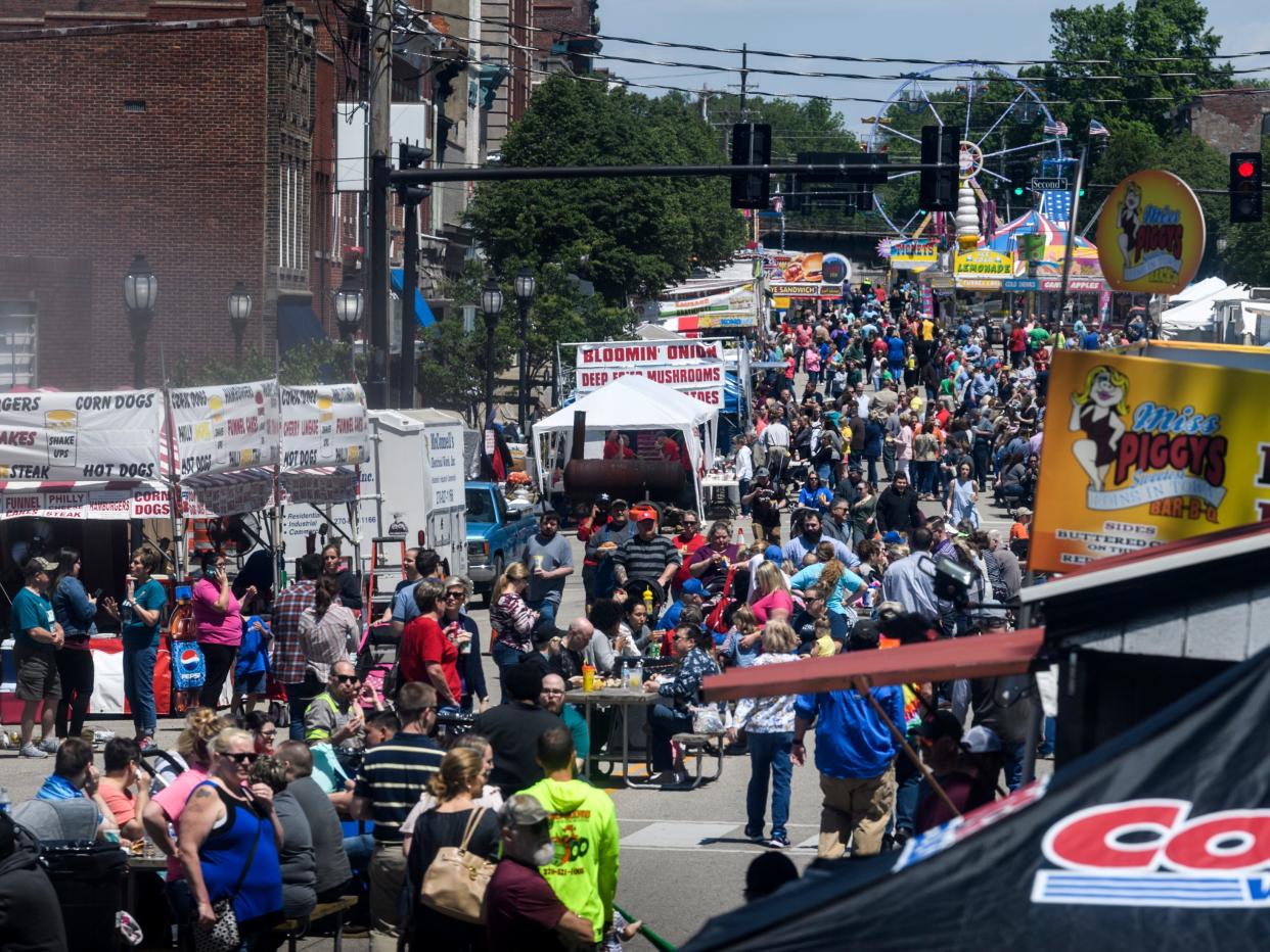 People walk along Main Street looking for a food booth to stop at during the lunchtime rush on the first day of the 2019 Henderson Breakfast Lions Club's 32nd annual Tri-Fest in downtown Henderson.