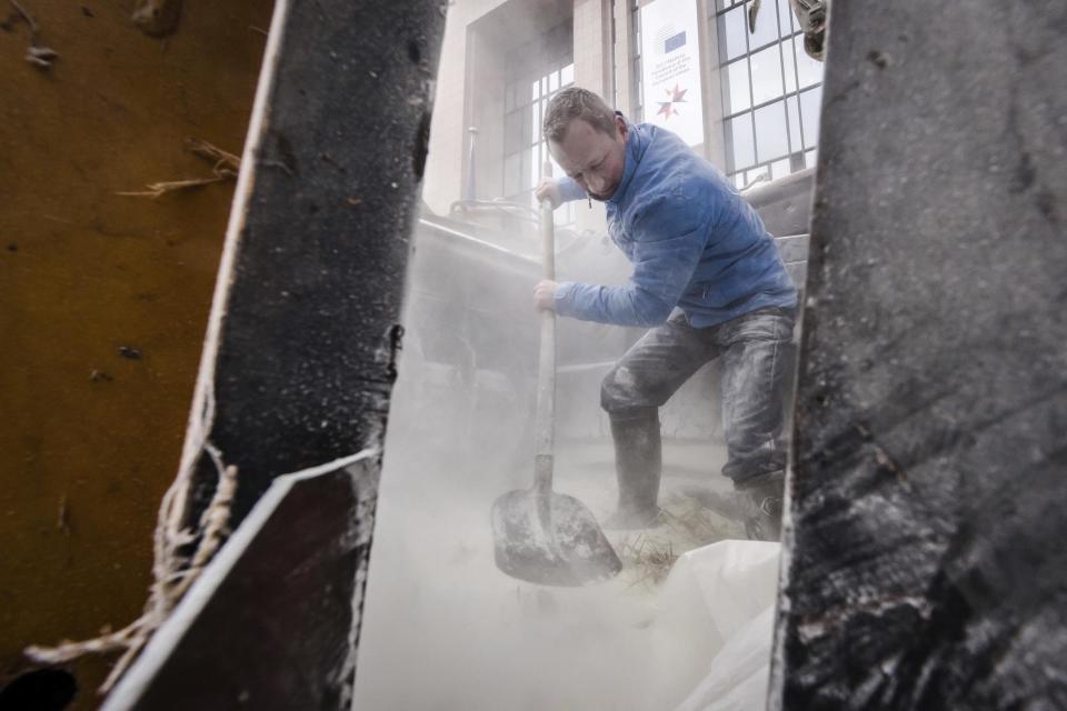 European dairy farmers spray the EU Council building with milk powder to protest the crisis in their sector, in Brussels on Monday, Jan. 23, 2017. The sector has been hit with sagging prices and production costs squeezing profits to the extent that has driven many farmers to the brink of bankruptcy. The EU's executive Commission has approved some support measures over the past year, but the farmers fear that releasing more milk powder on the market would further complicate their plight. (AP Photo/Geert Vanden Wijngaert)