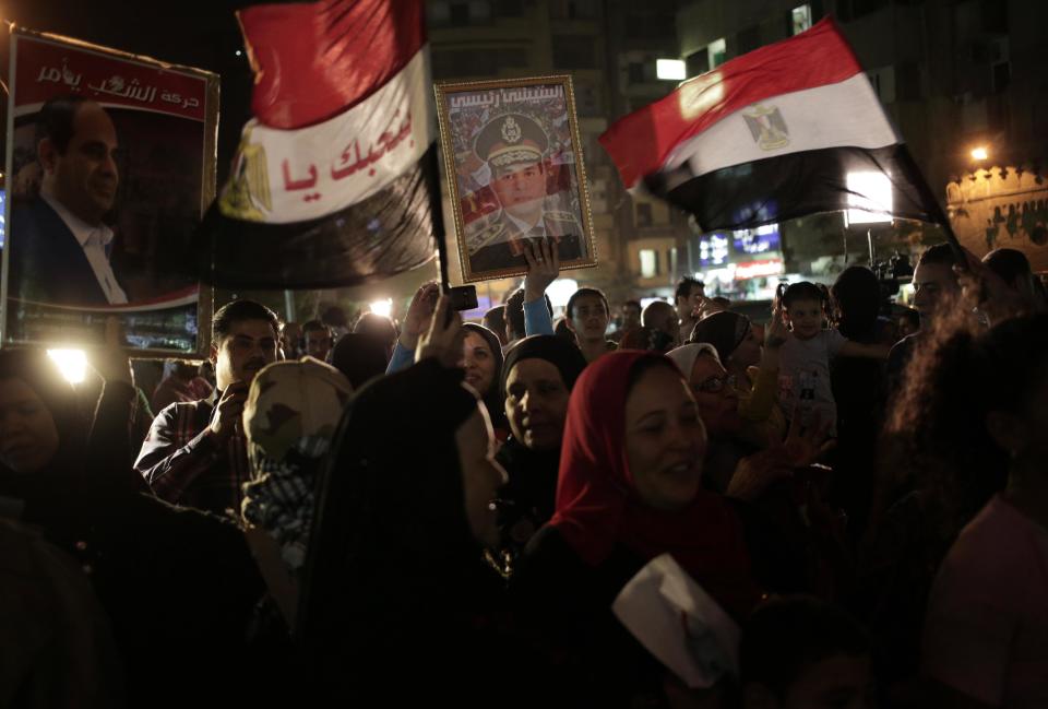 Supporters of Egypt's former army chief Abdel-Fattah el-Sissi gather to watch his first televised interview shown on a big screen on a street in downtown Cairo, Egypt, Monday, May 5, 2014. El-Sissi gave the first TV interview of his campaign to become Egypt's next president on Monday, saying he decided to run because of the threats facing the nation after his removal of the country's first democratically elected president, Islamist Mohammed Morsi. (AP Photo/Khalil Hamra)