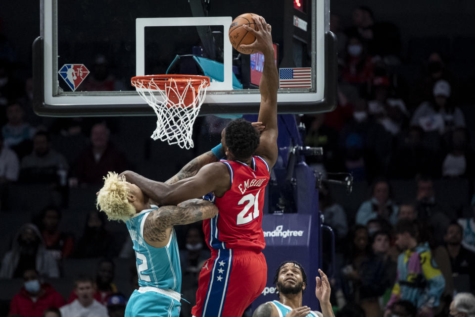 Philadelphia 76ers center Joel Embiid (21) is fouled while attempting to dunk over Charlotte Hornets guard Kelly Oubre Jr. (12) during the first half of an NBA basketball game, Wednesday, Dec. 8, 2021, in Charlotte, N.C. (AP Photo/Matt Kelley)