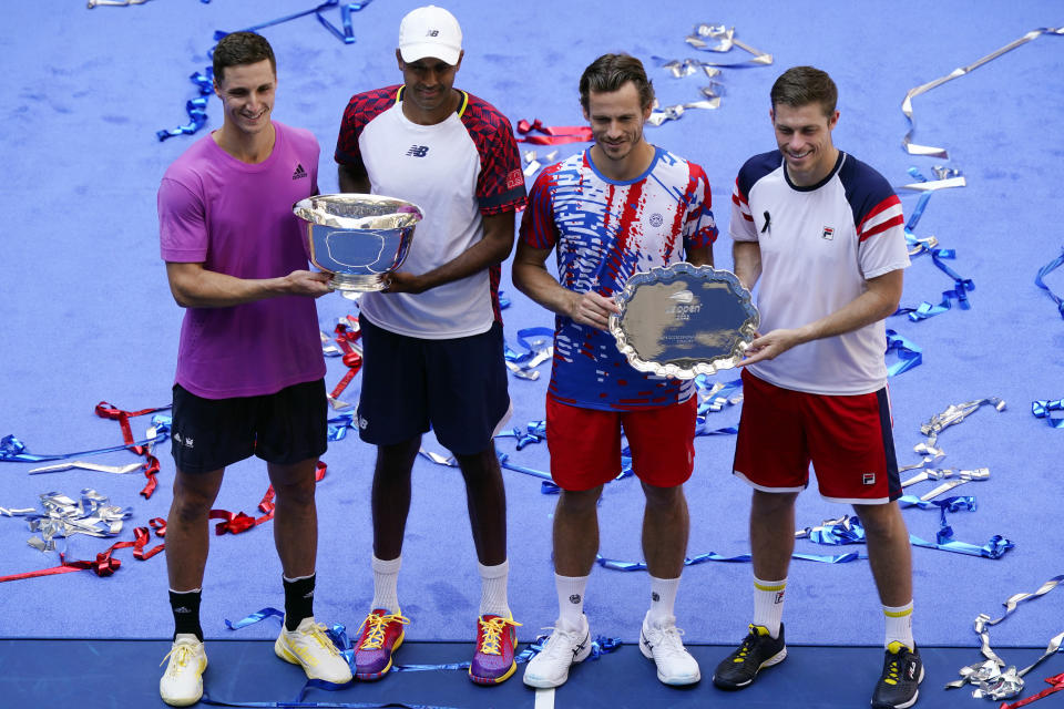 Rajeev Ram, of the United States, second from left, and Joe Salisbury, of Britain, left, pose for photos with the trophy after defeating Wesley Koolhof, of the Netherlands, second from right and Neal Skupski, of Britain, in the final of the men's doubles at the the U.S. Open tennis championships, Friday, Sept. 9, 2022, in New York. (AP Photo/Matt Rourke)