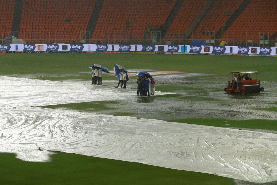 Ground staff huddle under umbrellas as rain delays the start of play during the 2023 IPL Final match between Chennai Super Kings and Gujarat Titans at Narendra Modi Stadium on 28 May 2023 in Ahmedabad (Getty Images)