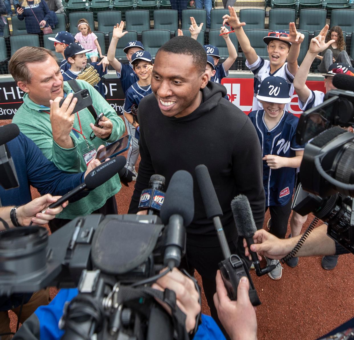 University of Louisville assistant basketball coach Nolan Smith speaks to the media after throwing out the first pitch at the Louisville Bats game. Throwing up the "L" in the background are the Wolves, a youth traveling baseball team. April 21, 2022