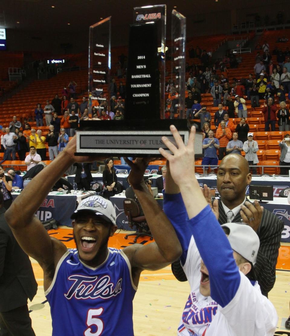 Tulsa Tim Peete, left, and Barrett Hunter, right, celebrate with the trophy as coach Danny Manning, background, claps after their 69-60 win over Louisiana Tech an NCAA college basketball game in the championship of the Conference USA tournament Saturday, March 15, 201, in El Paso, Texas. (AP Photo/Victor Calzada)