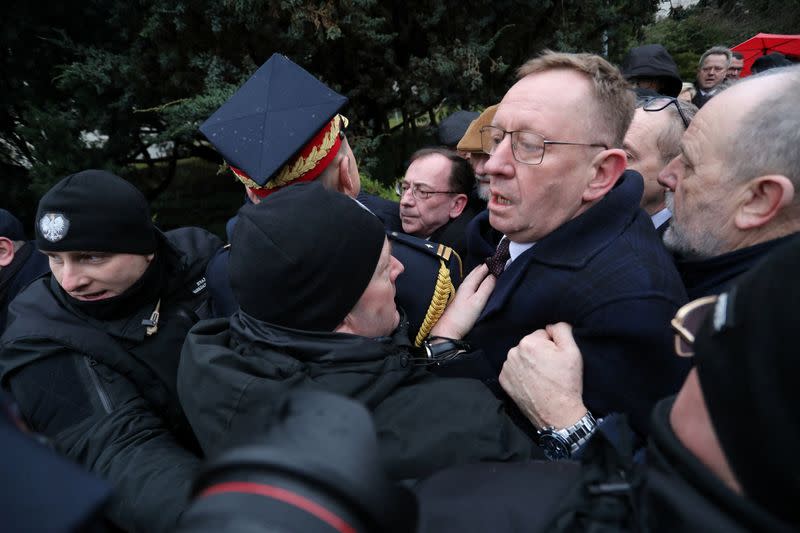 Former Interior Minister Kaminski surrounded by PiS politicians, is blocked by Marshal guard officers outside the parliament building in Warsaw