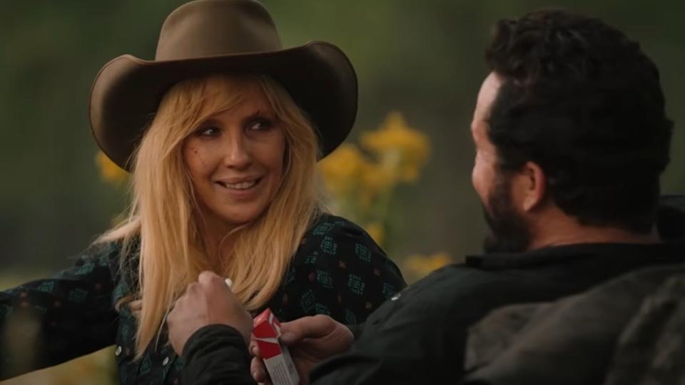 Beth smiling at Rip while sitting in a meadow.