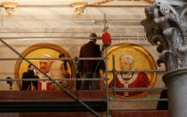 FILE PHOTO: Workers install a mosaic depicting Pope Francis next to the one depicting Pope Emeritus Benedict XVI at Saint Paul's Basilica in Rome