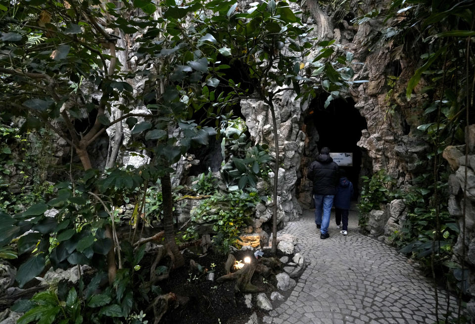 A parent and child take a walk through the greenhouse after the son received a COVID-19 vaccine at the Antwerp Zoo in Antwerp, Belgium, Wednesday, Jan. 12, 2022. In an effort to make children more at ease in getting their vaccine, specially designed safari tents with photos of zoo animals have been installed to provide a more private setting with a vaccinator. Once they have received the vaccine, children and parents can stroll through the greenhouse and visit the monkey enclosure. (AP Photo/Virginia Mayo)