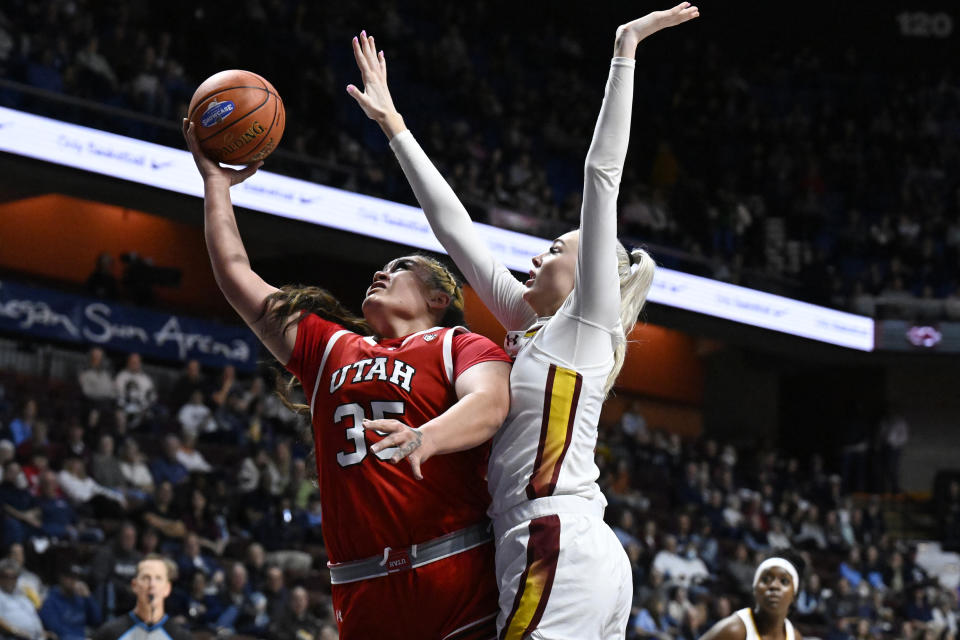 Utah forward Alissa Pili (35) shoots as South Carolina forward Chloe Kitts, center right, defends in the second half of an NCAA college basketball game, Sunday, Dec. 10, 2023, in Uncasville, Conn. (AP Photo/Jessica Hill)