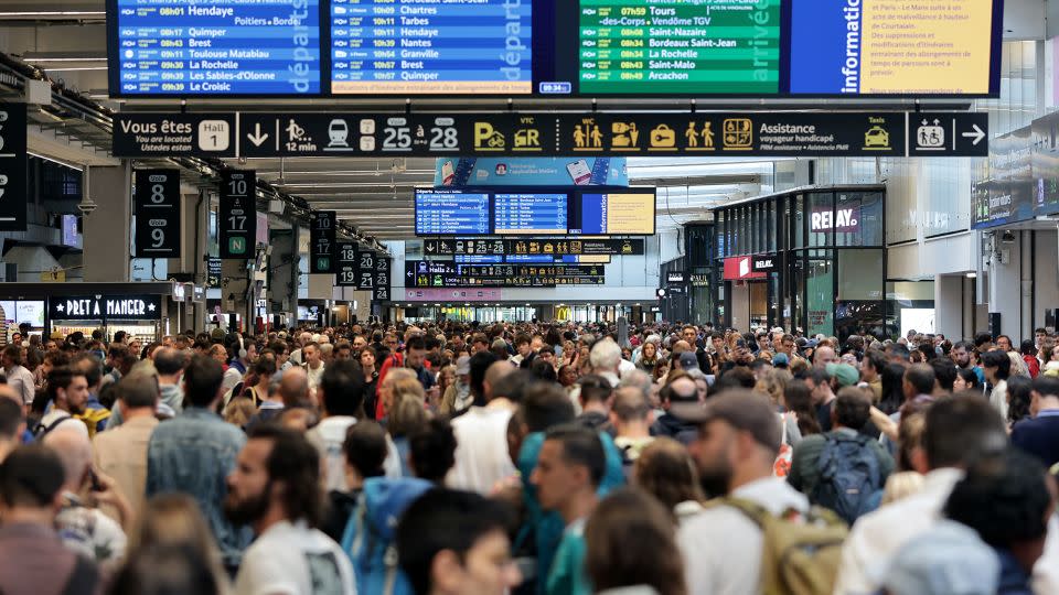 Passengers gather around the departure boards at the Gare Montparnasse train station in Paris. - Thibaud Moritz/AFP/Getty Images