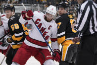 Carolina Hurricanes' Jordan Staal (11) and Pittsburgh Penguins' Sidney Crosby (87) get tangled after taking a face-off during the second period of an NHL hockey game in Pittsburgh, Sunday, March 13, 2022. (AP Photo/Gene J. Puskar)