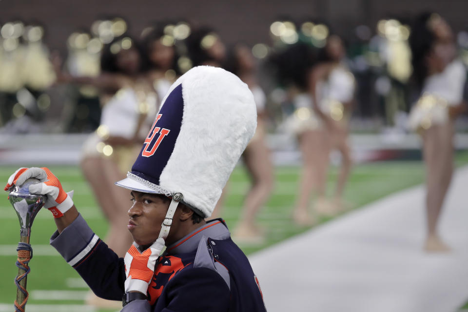 A drum major with the Langston University Marching Pride marching band adjusts his chin strap during a break in their performance at the 2023 National Battle of the Bands, a showcase for HBCU marching bands, held at NRG Stadium, Saturday, Aug. 26, 2023, in Houston. (AP Photo/Michael Wyke)