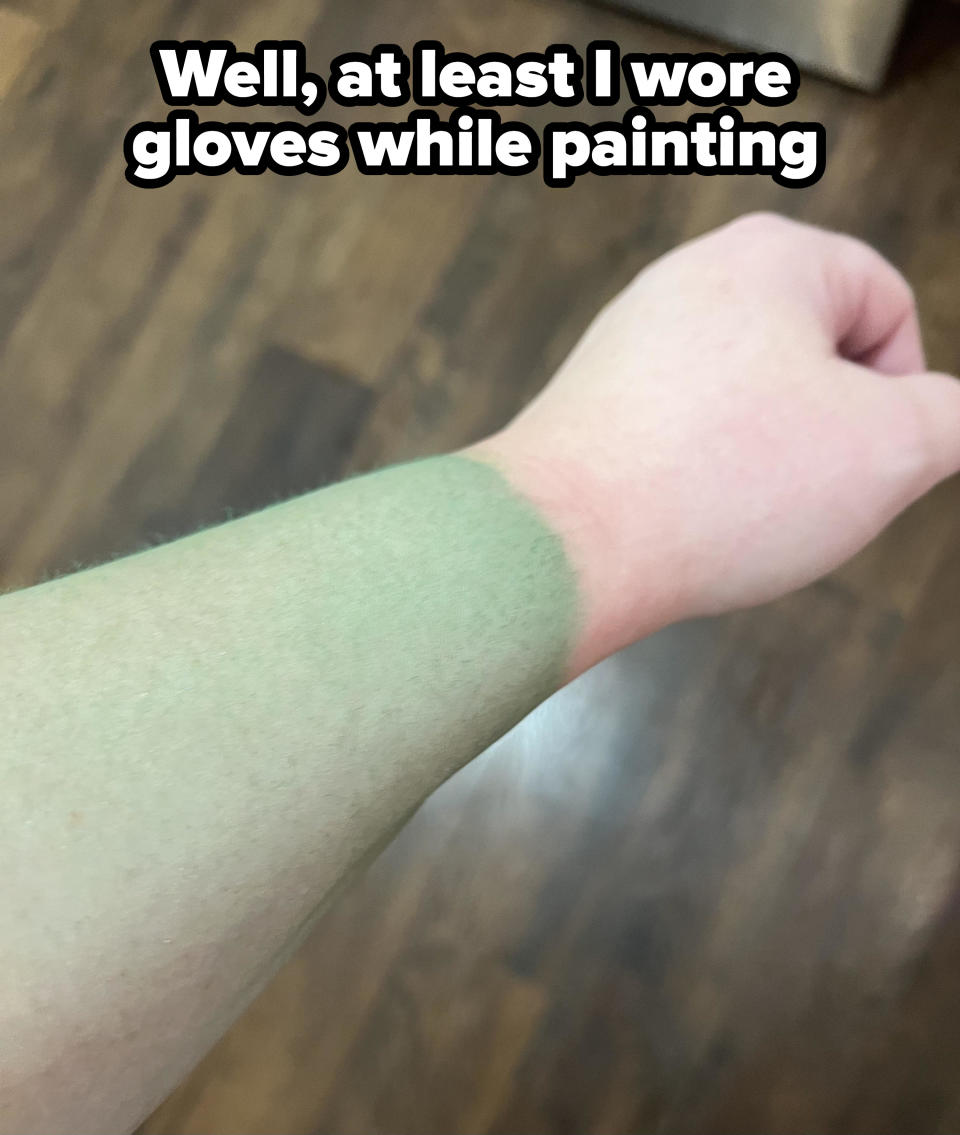 A person's arm and hand are partially covered in green paint, with text stating, "Well, at least I wore gloves while painting."