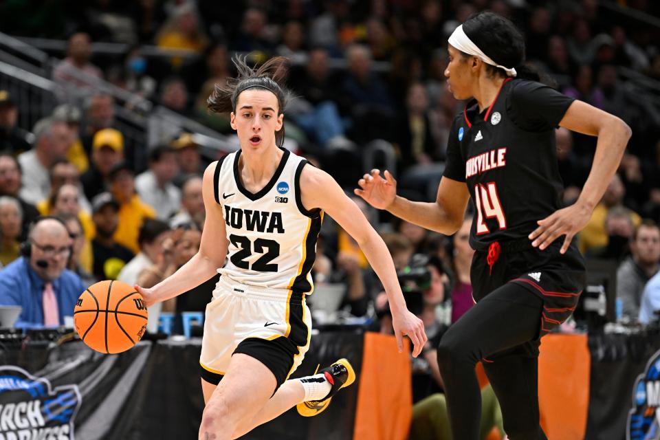 Iowa guard Caitlin Clark (22)  dribbles the ball against Louisville during the second quarter of their Elite Eight game.