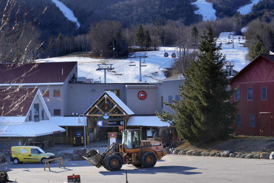 Heavy machinery works to clear debris near a lodge at the Sunday River ski resort following this week's disastrous rainstorm, Thursday, Dec. 21, 2023, in Newry, Maine. (AP Photo/Robert F. Bukaty)