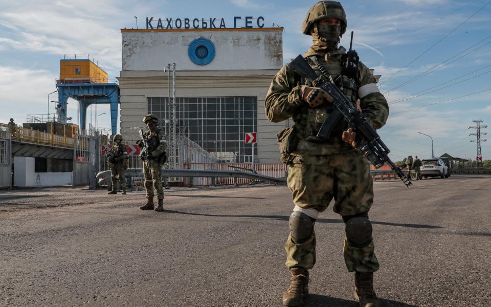 Russian troops standing guard at a power plant near Kherson, Ukraine - Sergei Ilnitsky/Shutterstock