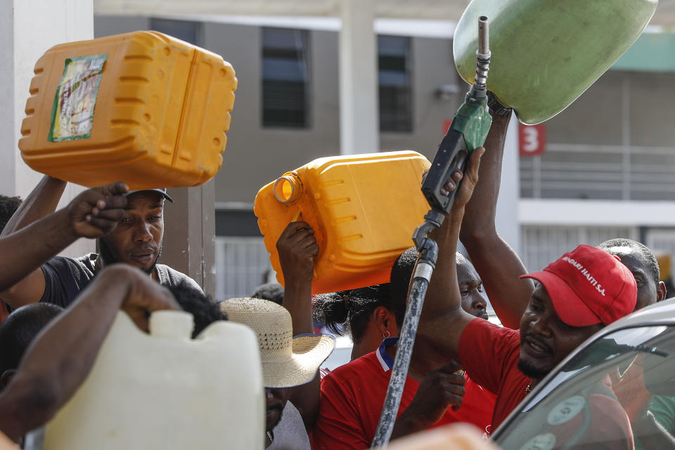 People push and shove as they try to get their gas tanks filled at a gas station in Port-au-Prince, Haiti, Sunday, Nov. 14, 2021. (AP Photo/Odelyn Joseph)