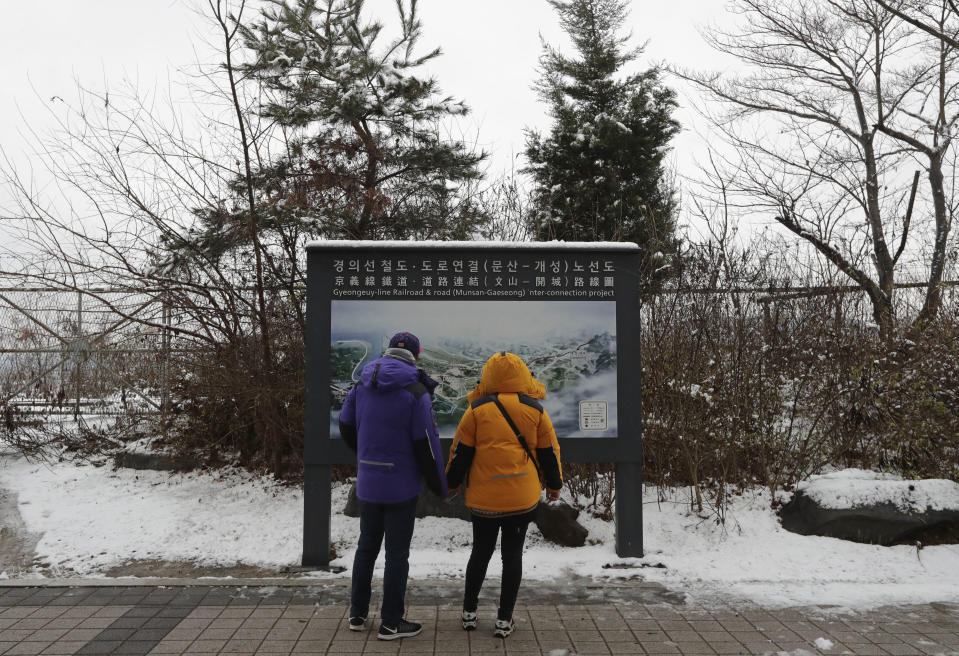 Visitors look at a map of railroad and road between two Koreas cities, South's Munsan and North's Kaesong, at the Imjingak Pavilion in Paju, South Korea, Saturday, Nov. 24, 2018. South Korea said Saturday that the United Nations Security Council granted an exemption to sanctions that will allow surveys on North Korean railroad sections the Koreas want to connect with the South. (AP Photo/Lee Jin-man)