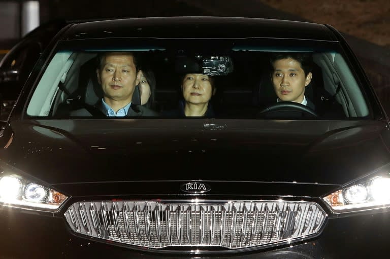 Ousted South Korean President Park Geun-hye (C), leaves the prosecutors' office in a car as she is transferred to a detention house early on March 31, 2017 in Seoul