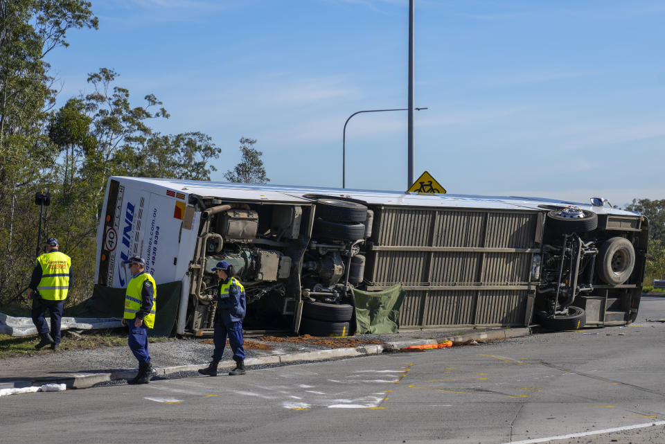 Policías inspeccionan un autobús el lunes 12 de junio de 2023, el cual se volcó cerca de la localidad de Greta en el Valle de Hunter, al norte de Sydney, Australia. (AP Foto/Mark Baker)