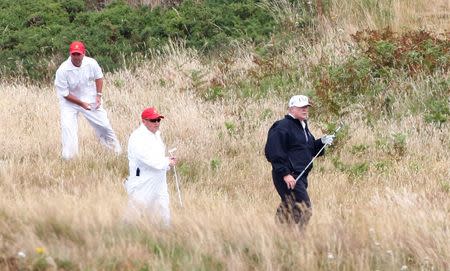 U.S. President Donald Trump carries a golf club at his golf resort, in Turnberry, Scotland July 14, 2018. REUTERS/Henry Nicholls