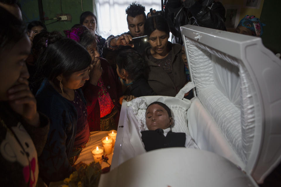 FILE - In this Jan. 26, 2019, file photo, family members pay their final respects to Felipe Gomez Alonzo in Yalambojoch, Guatemala. The 8-year-old migrant boy died in U.S. custody at a New Mexico hospital on Christmas Eve. Felipe and his father were apprehended by the U.S. Border Patrol in mid-December. Homeland Security's watchdog found no wrongdoing or misconduct by immigration officials in the deaths of two migrant children last December. (AP Photo/Oliver de Ros, File)