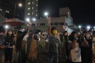 Supporters wave flashlights outside the Apple Daily headquarters in Hong Kong, Wednesday, June 23, 2021. Hong Kong's pro-democracy Apple Daily newspaper will stop publishing Thursday, following last week's arrest of five editors and executives and the freezing of $2.3 million in assets under the city's one-year-old national security law. (AP Photo/Kin Cheung)