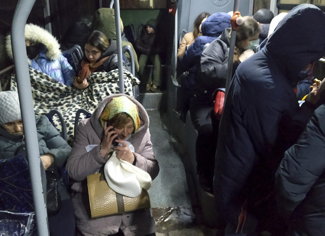 People sit inside a but waiting to be evacuate to Russia amid crisis in Donetsk, the territory controlled by pro-Russian militants, eastern Ukraine, Friday, Feb. 18, 2022. Spiking tensions in eastern Ukraine on Friday aggravated Western fears of a Russian invasion and a new war in Europe, with a humanitarian convoy hit by shelling and pro-Russian rebels evacuating civilians from the conflict zone. A car bombing hit the eastern city of Donetsk, but no casualties were reported. (AP Photo/Alexei Alexandrov)