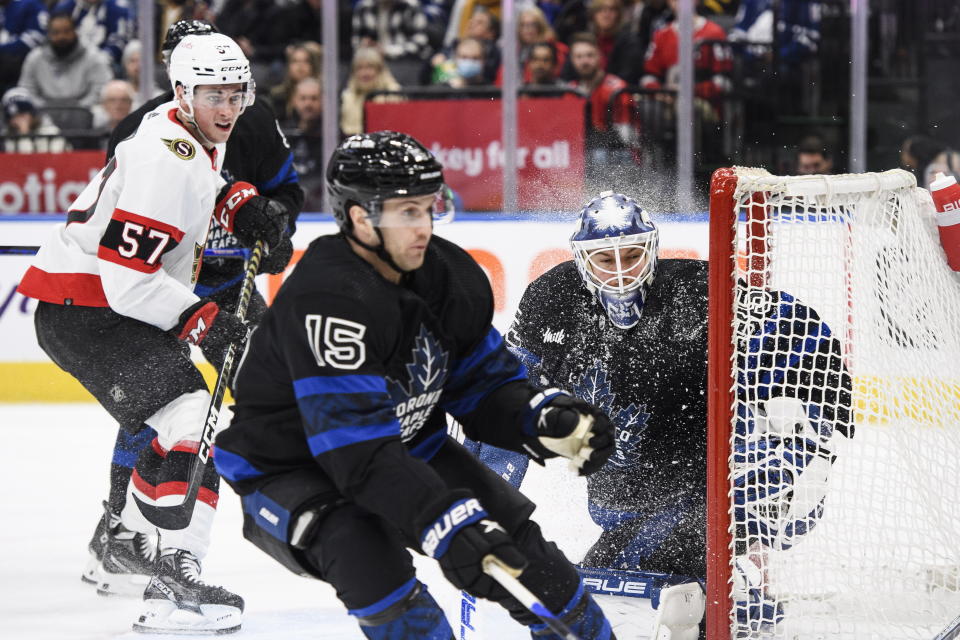 Toronto Maple Leafs goaltender Ilya Samsonov (35) and forward Alexander Kerfoot (15) and Ottawa Senators forward Shane Pinto (57) look for the puck during the first period of an NHL hockey game Friday, Jan. 27, 2023, in Toronto. (Christopher Katsarov/The Canadian Press via AP)