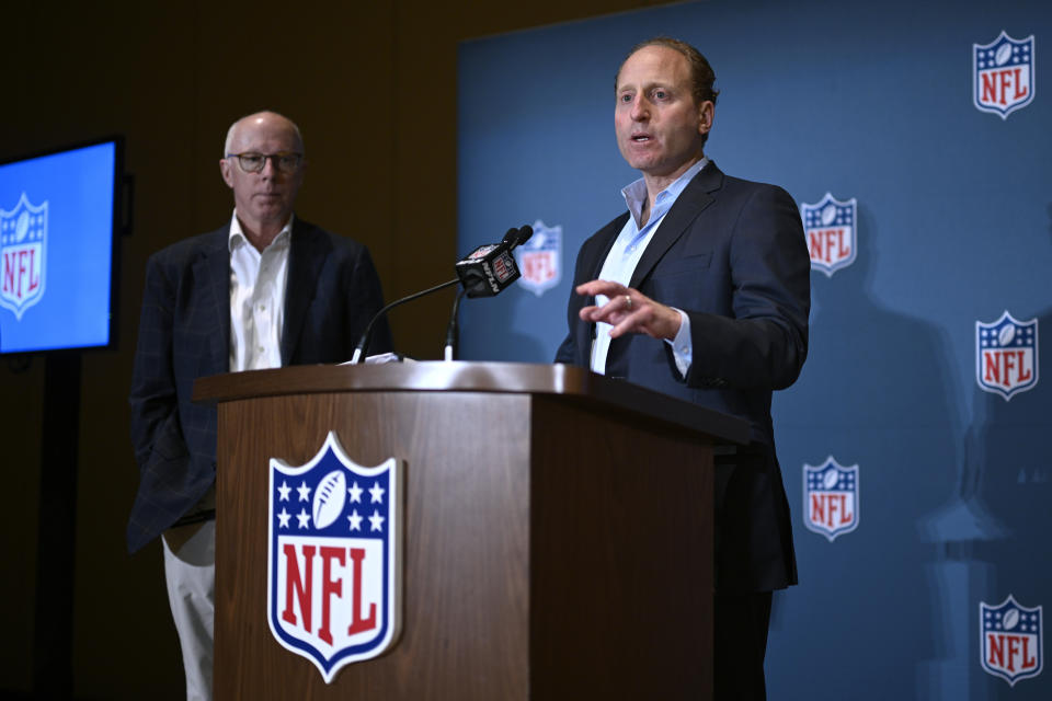 Rich McKay, left, Atlanta Falcons CEO and Competition Committee Chairman, looks on as Jeff Miller, NFL Executive Vice President of Communications, addresses reporters about rules changes at the NFL owners meetings, Monday, March 25, 2024, in Orlando, Fla. (AP Photo/Phelan M. Ebenhack)