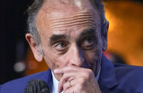 FILE - In this Oct.19, 2021 file photo, Eric Zemmour listens during a meeting to promote his latest book "La France n'a pas dit son dernier mot" (France has not yet said its last word) in Versailles, west of Paris. Eric Zemmour is a rabble-rousing television pundit and author with repeated convictions for hate speech who is finding large and fervent audiences for his anti-Islam, anti-immigration invective in the early stages of France's presidential race. He is packing auditoriums with paying crowds and filling supporters' heads with visions of a Trump-like leap from the small screen to the presidential Elysee Palace when France votes in April. (AP Photo/Michel Euler, File)