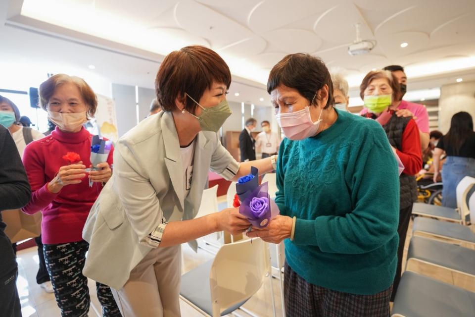 《圖說》龔雅雯執行長贈花給長者。〈文化局提供〉