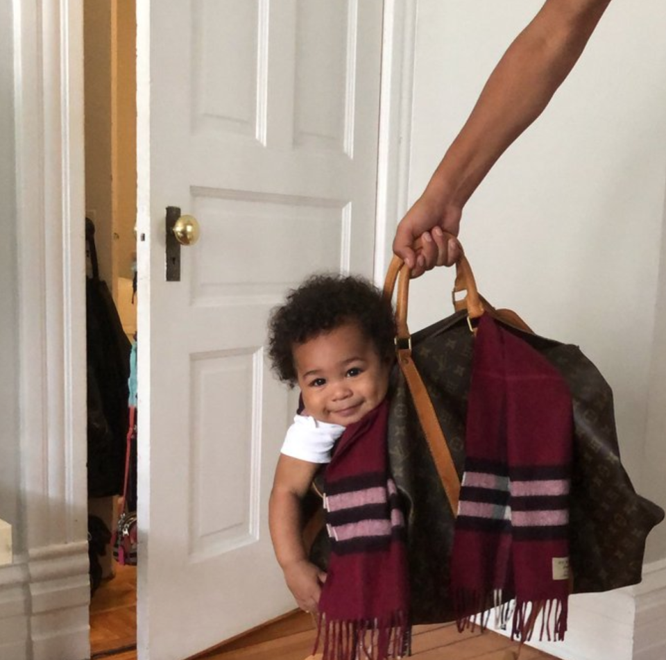 A photo of 9-month-old Lamar Jr., happily sitting in a purse is going viral. (Photo: Twitter/__Ily4)